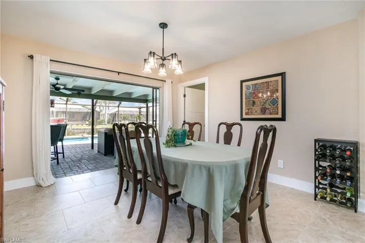 Dining area featuring a chandelier, wine cooler, and baseboards