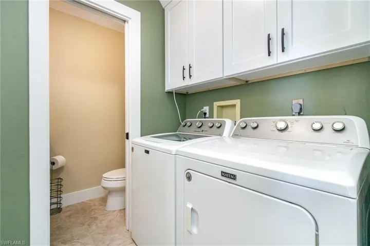 Laundry room with washer and dryer and baseboards