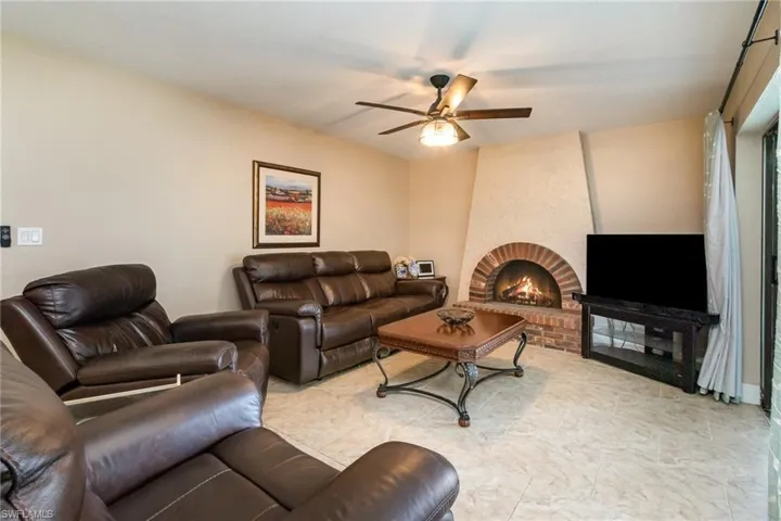 Living room featuring a fireplace and a ceiling fan