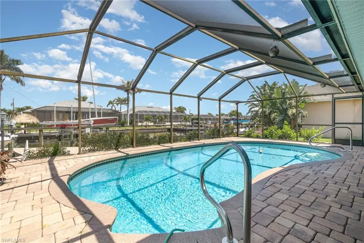 Outdoor pool with a patio, a residential view, and glass enclosure