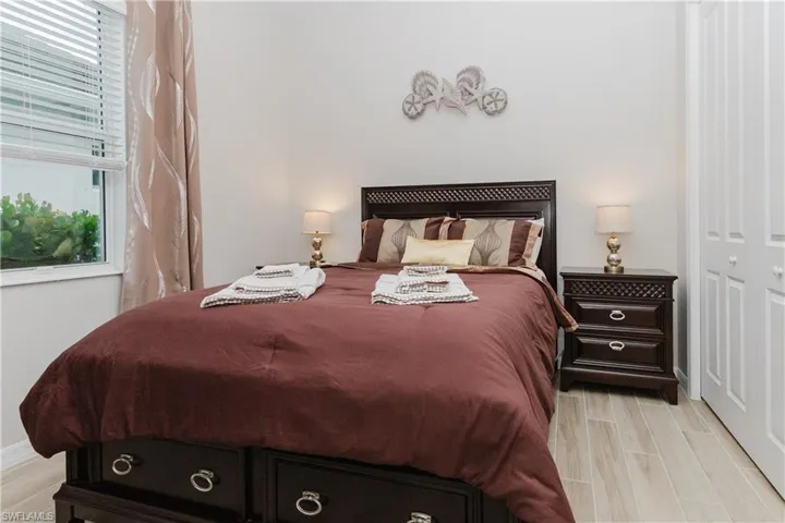 Wood look tile flooring, ample natural light, and louvered bi-fold closet doors