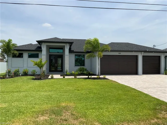 View of front of home with a front lawn and a garage