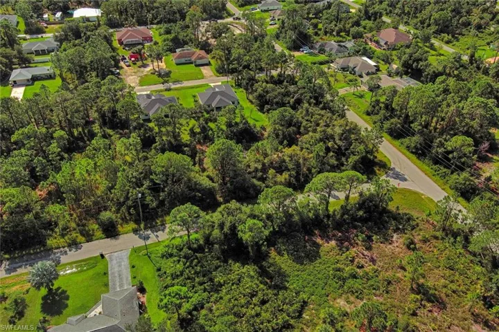 Aerial view of residential area featuring a tree filled landscape