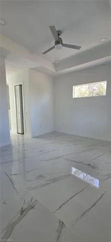 Spare room with a ceiling fan and light marble finish flooring