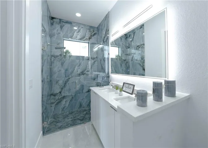 Bathroom with vanity and tiled shower