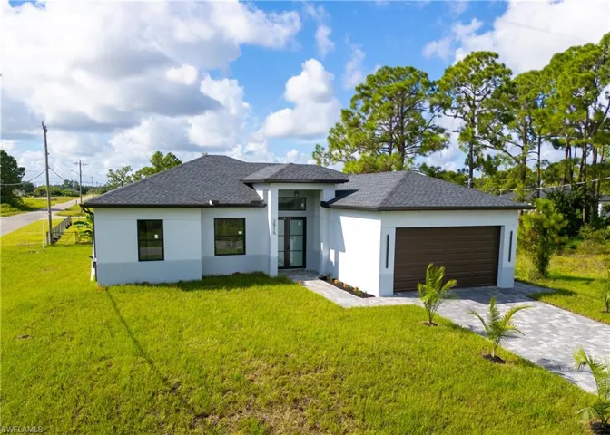 View of front of house with a front yard and a garage