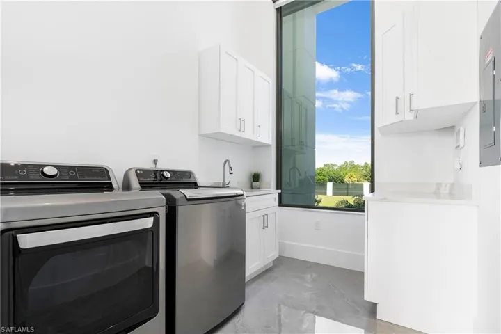 Washroom featuring cabinets and washing machine and dryer