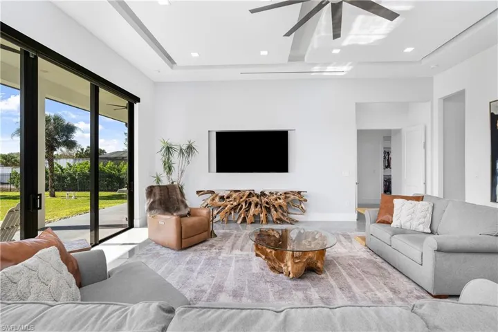 Living room featuring ceiling fan and a tray ceiling