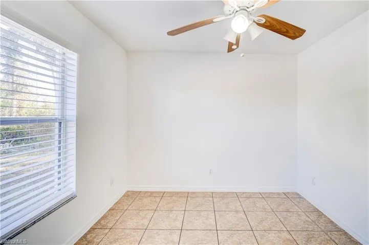 Unfurnished room with a ceiling fan and light tile patterned floors