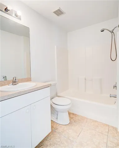 Full bath with vanity, washtub / shower combination, and light tile patterned flooring