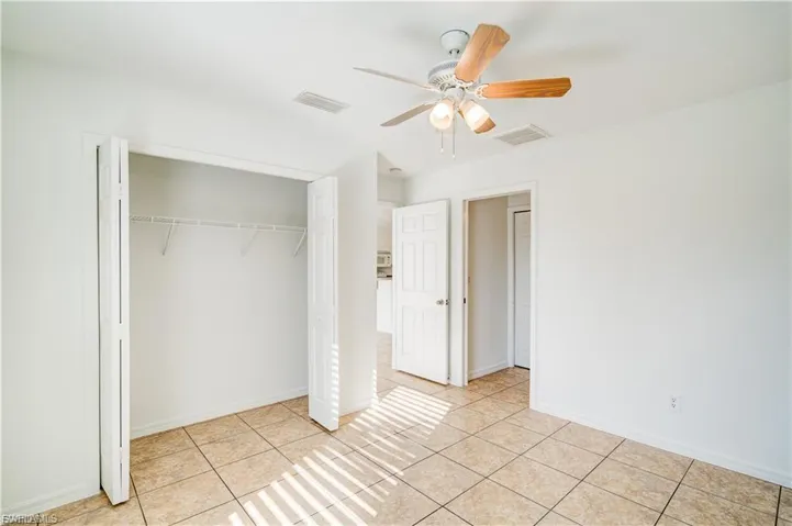 Unfurnished bedroom with a ceiling fan, a closet, and light tile patterned floors