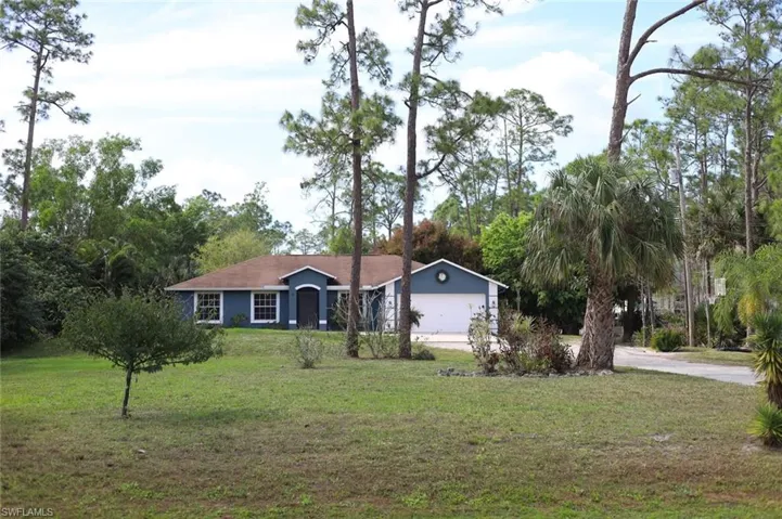 Ranch-style house featuring a front lawn, concrete driveway, and a garage