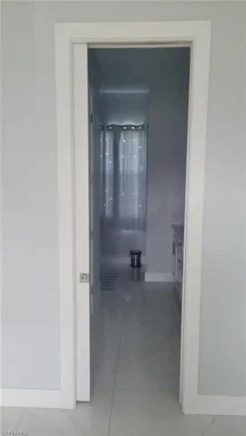 Pocket door entry featuring white trim and a satin nickel handle