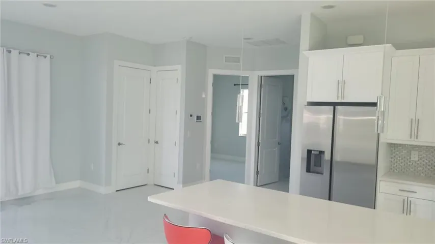 Kitchen with white cabinetry and stainless steel refrigerator