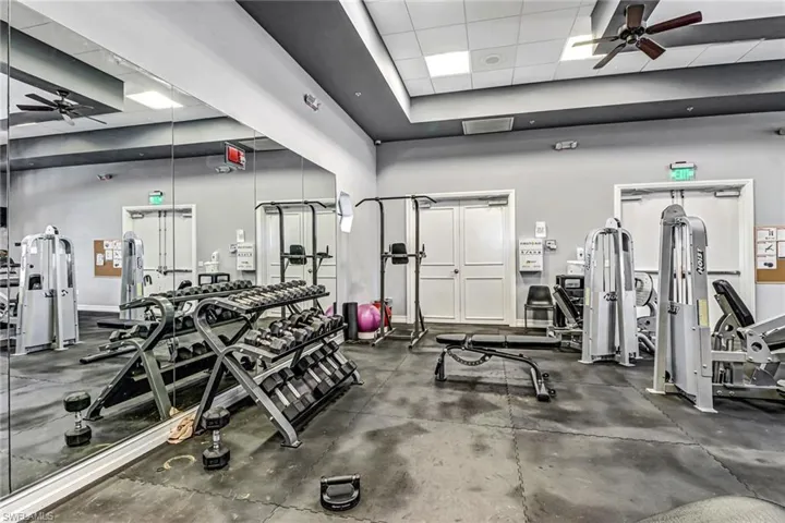 Gym featuring a ceiling fan and a paneled ceiling