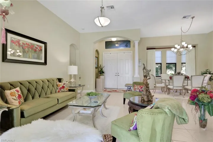 Tiled living room with arched walkways and a chandelier