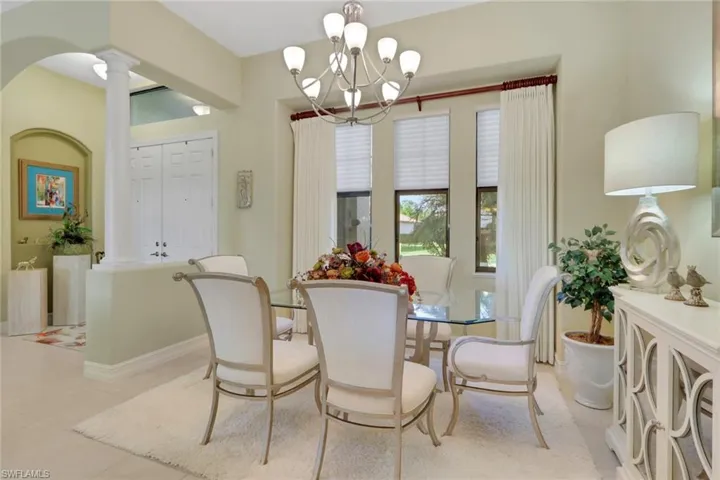Tiled dining room with a chandelier and decorative columns