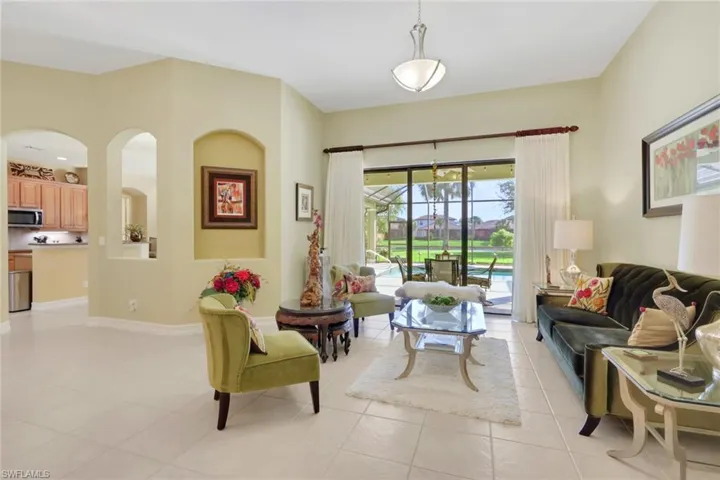 Living room with a sunroom and light tile patterned floors