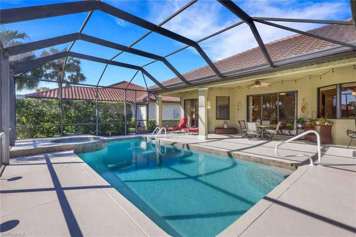 View of swimming pool featuring a patio area, a sunroom, glass enclosure, and a pool with connected hot tub