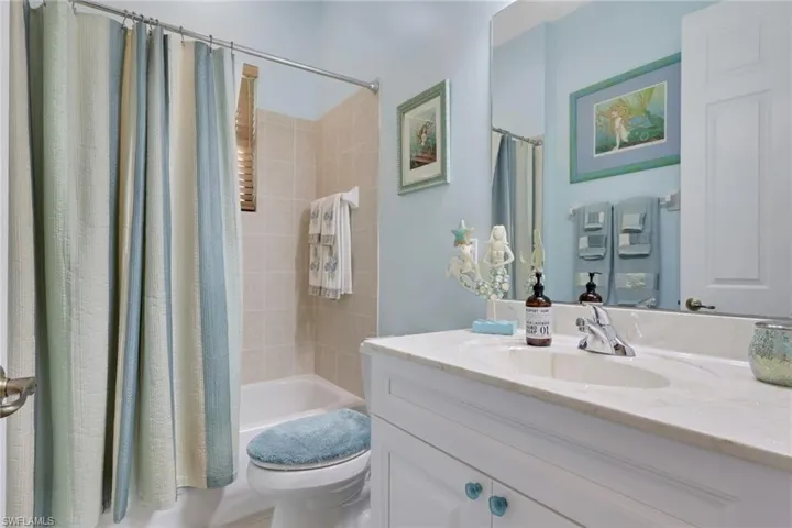 Bathroom featuring vanity and shower / bath combo with shower curtain