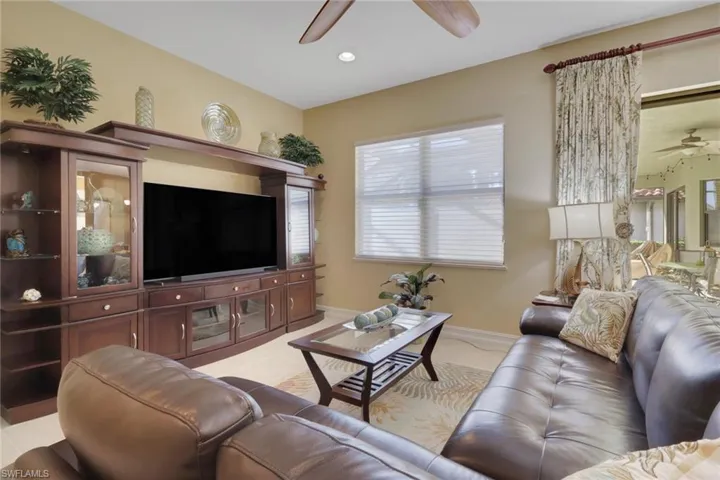 Living area featuring a ceiling fan and baseboards