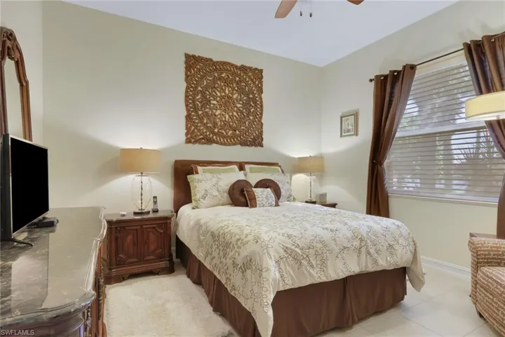 Bedroom with ceiling fan and light tile patterned floors