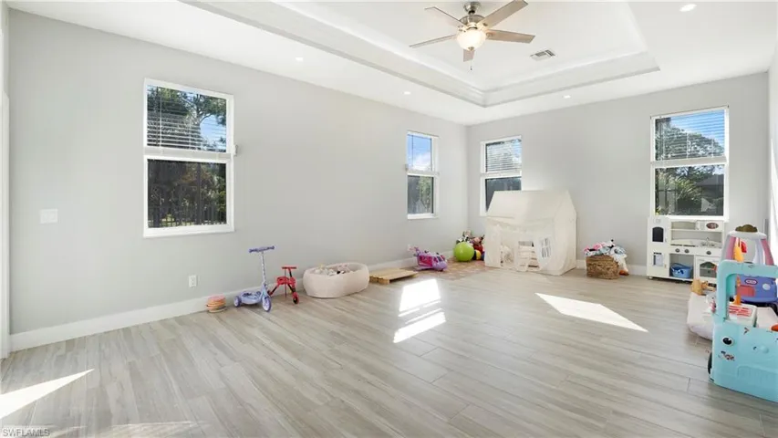 Playroom featuring wood finish floors, healthy amount of natural light, recessed lighting, and ceiling fan