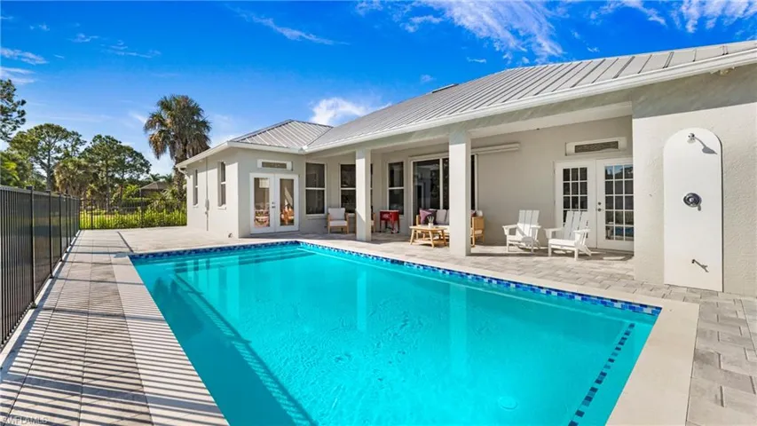 View of swimming pool with french doors and a patio