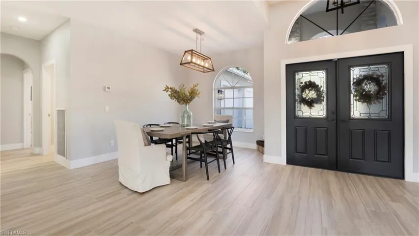Entryway featuring french doors, arched walkways, and light wood-type flooring