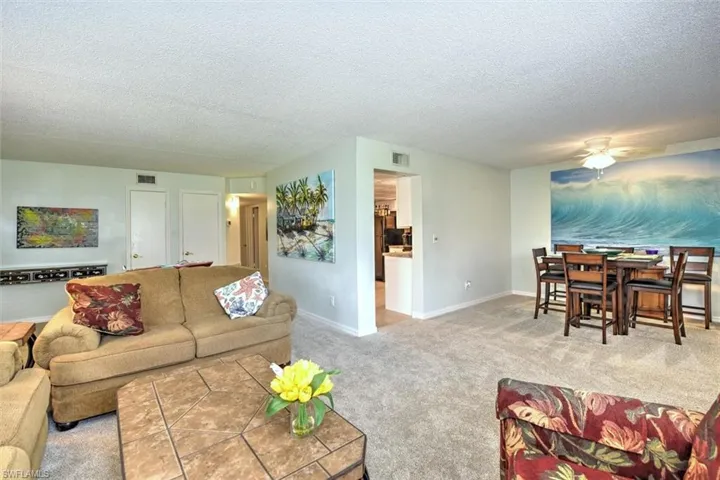 Spacious living area featuring light-colored carpet flooring and a neutral wall palette