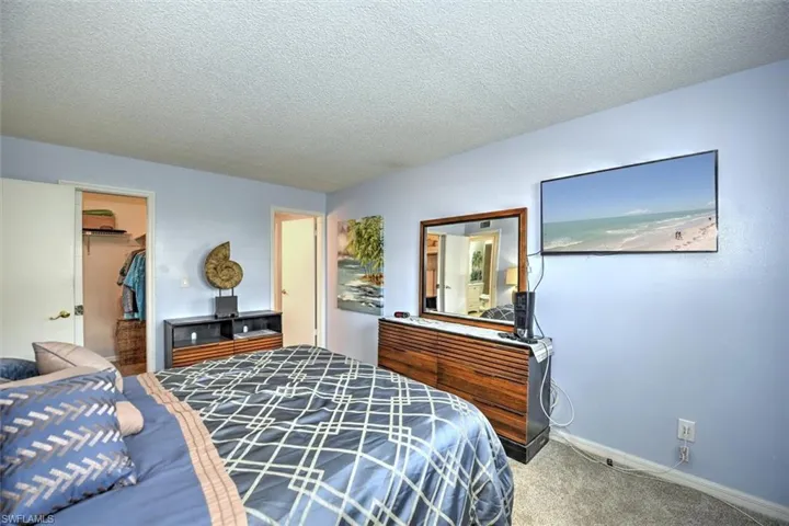 Bedroom featuring light blue walls and textured white ceilings