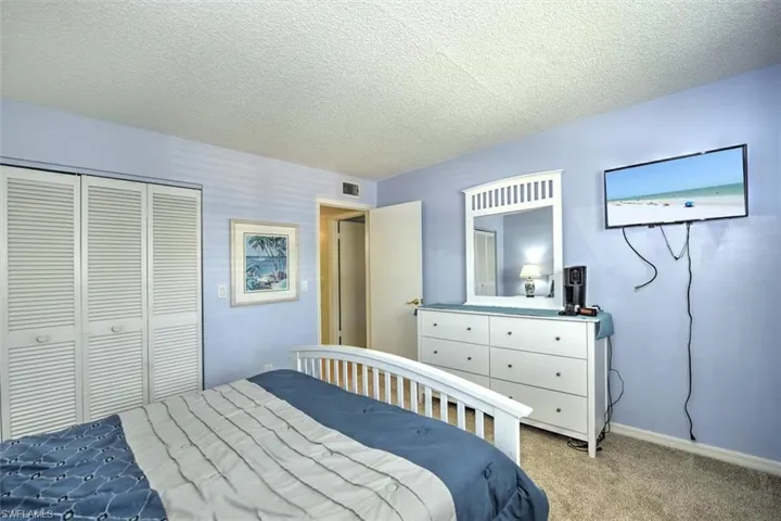 Spacious room featuring light blue walls and neutral carpet flooring