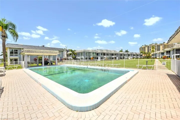 Rectangular swimming pool with light blue tile coping and a surrounding paver patio