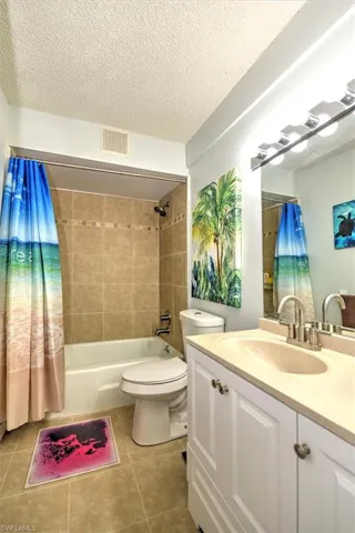 Bathroom featuring a white vanity with a single basin sink, integrated mirror, and overhead strip lighting
