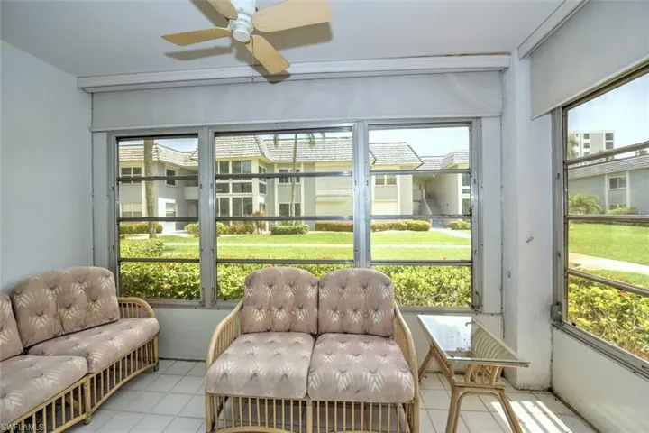Screened-in porch featuring multiple windows overlooking landscaped grounds