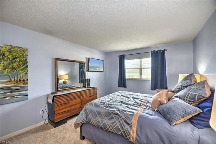 Carpeted room with light blue walls and a textured white ceiling