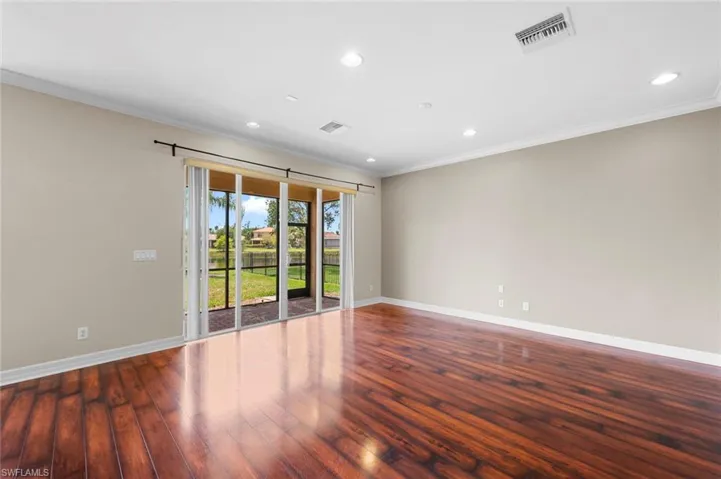 Spare room with ornamental molding, recessed lighting, and wood-type flooring