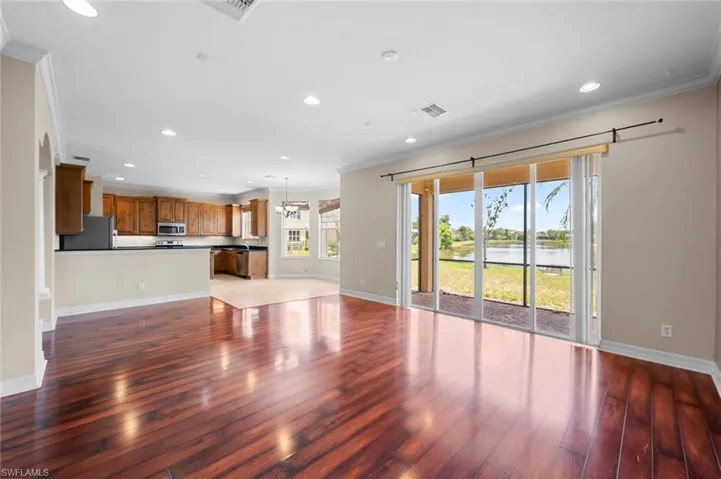 Unfurnished living room featuring ornamental molding, a water view, recessed lighting, light wood-style floors, and a chandelier