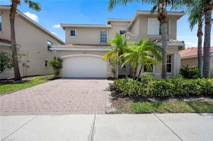 Mediterranean / spanish-style house featuring decorative driveway, stucco siding, a tiled roof, and an attached garage