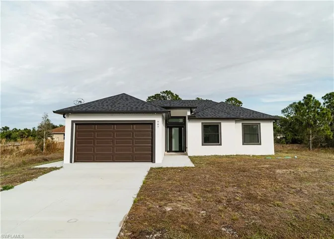 Prairie-style house with stucco siding, driveway, a garage, and roof with shingles