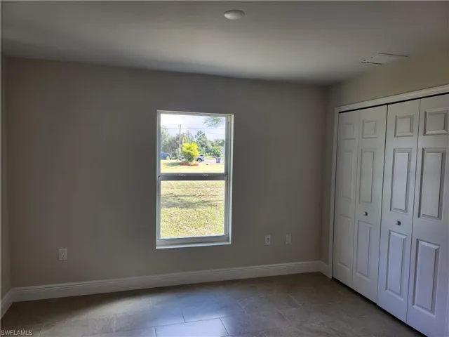 Unfurnished bedroom featuring baseboards and a closet