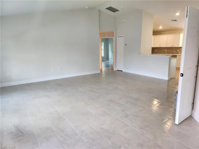 Unfurnished living room featuring baseboards and recessed lighting