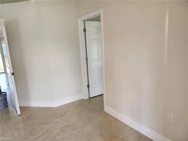 Unfurnished room featuring baseboards
