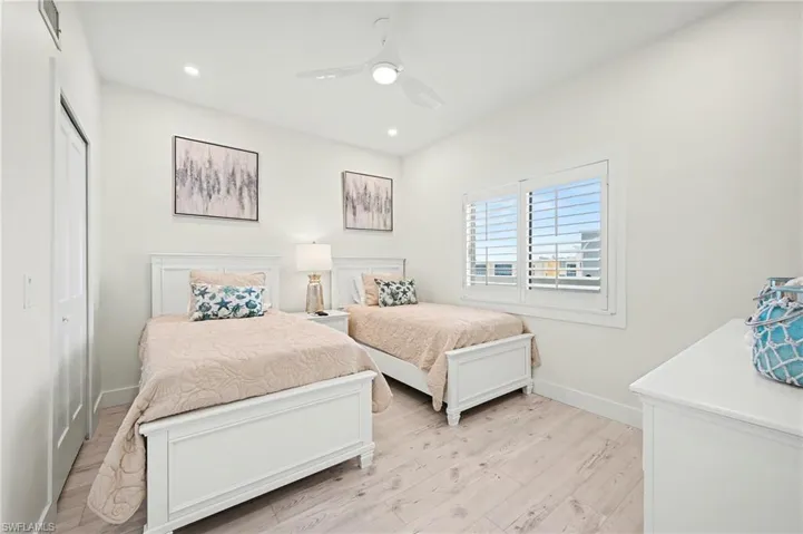 Bedroom with light vinyl tile floors, ceiling fan, and recessed lighting