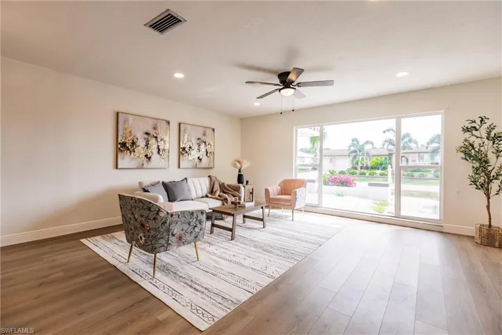 Living area featuring ceiling fan and dark hardwood / wood-style flooring