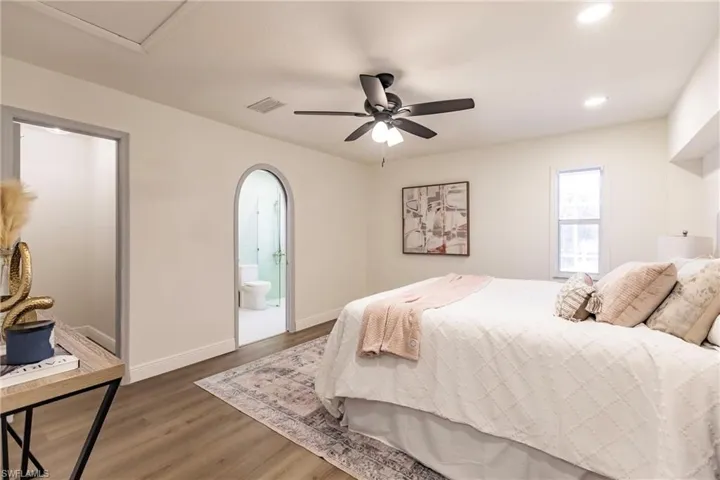 Bedroom with hardwood / wood-style floors, ensuite bathroom, and ceiling fan