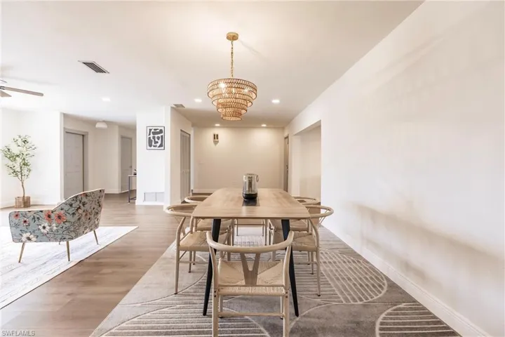 Dining area featuring ceiling fan with notable chandelier and hardwood / wood-style flooring