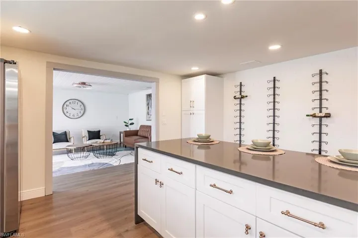 Kitchen featuring light hardwood / wood-style floors, white cabinets, and stainless steel fridge