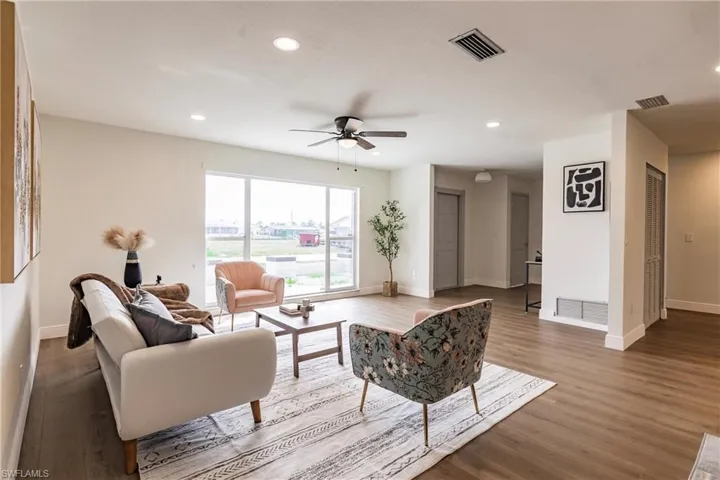 Living room with ceiling fan and wood-type flooring