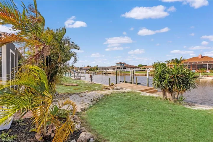 View of yard with a boat dock and a water view